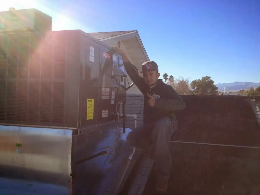 HVAC technician performing Air Duct Repair on a rooftop unit in Redwood Falls